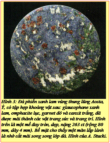 Text Box: Hình 3: Đá phiến xanh lam vùng thung lũng Aosta, Ý, có tập hợp khoáng vật sau: glaucophane xanh lam, omphacite lục, garnet đỏ và canxit trắng, đã được mài thành các vật trang sức và trang trí. Hình trên là một mề đay tròn, dẹp, nặng 263 ct (rộng 80 mm, dày 4 mm). Bề mặt cho thấy một màn lấp lánh là nhờ cắt mài song song lớp đá. Hình của A. Stucki. 