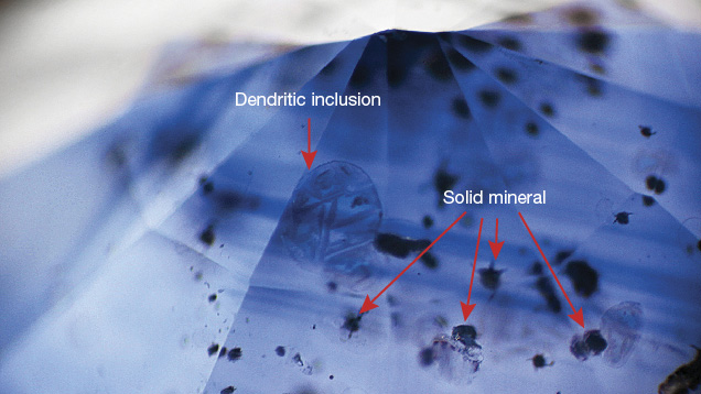 Description: Color zoning and mineral inclusions in a blue sapphire.